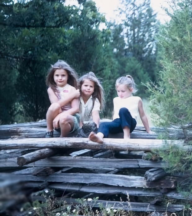My sister, friend and me sitting on a fort we built from an old snake rail fence.